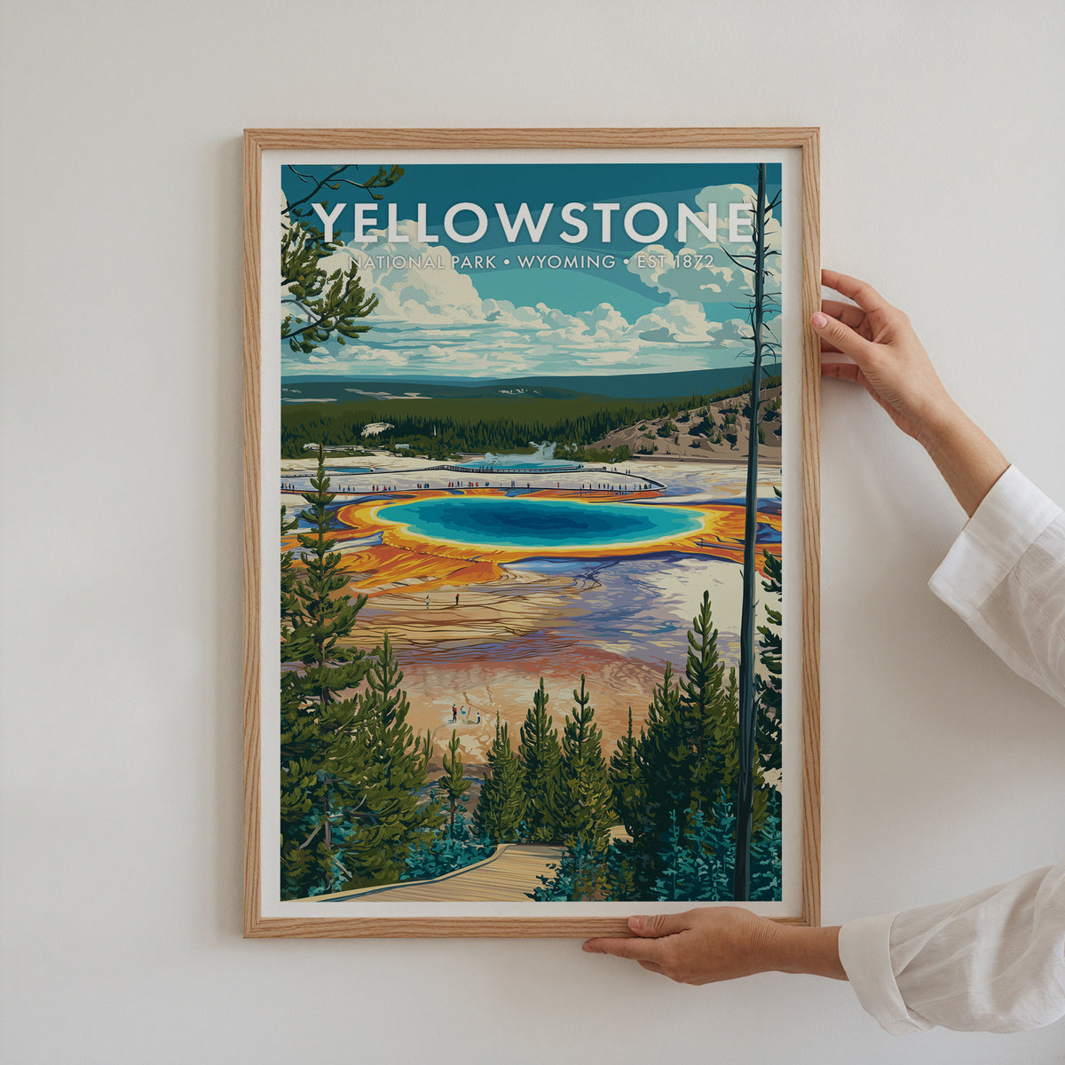 Yellowstone National Park mid-century modern art print in a light oak frame being hung on a bright white wall