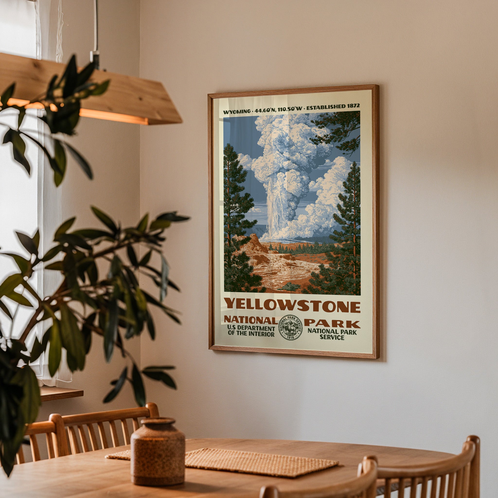 Yellowstone National Park vintage travel print hung above a wooden dining table under a pendant lamp