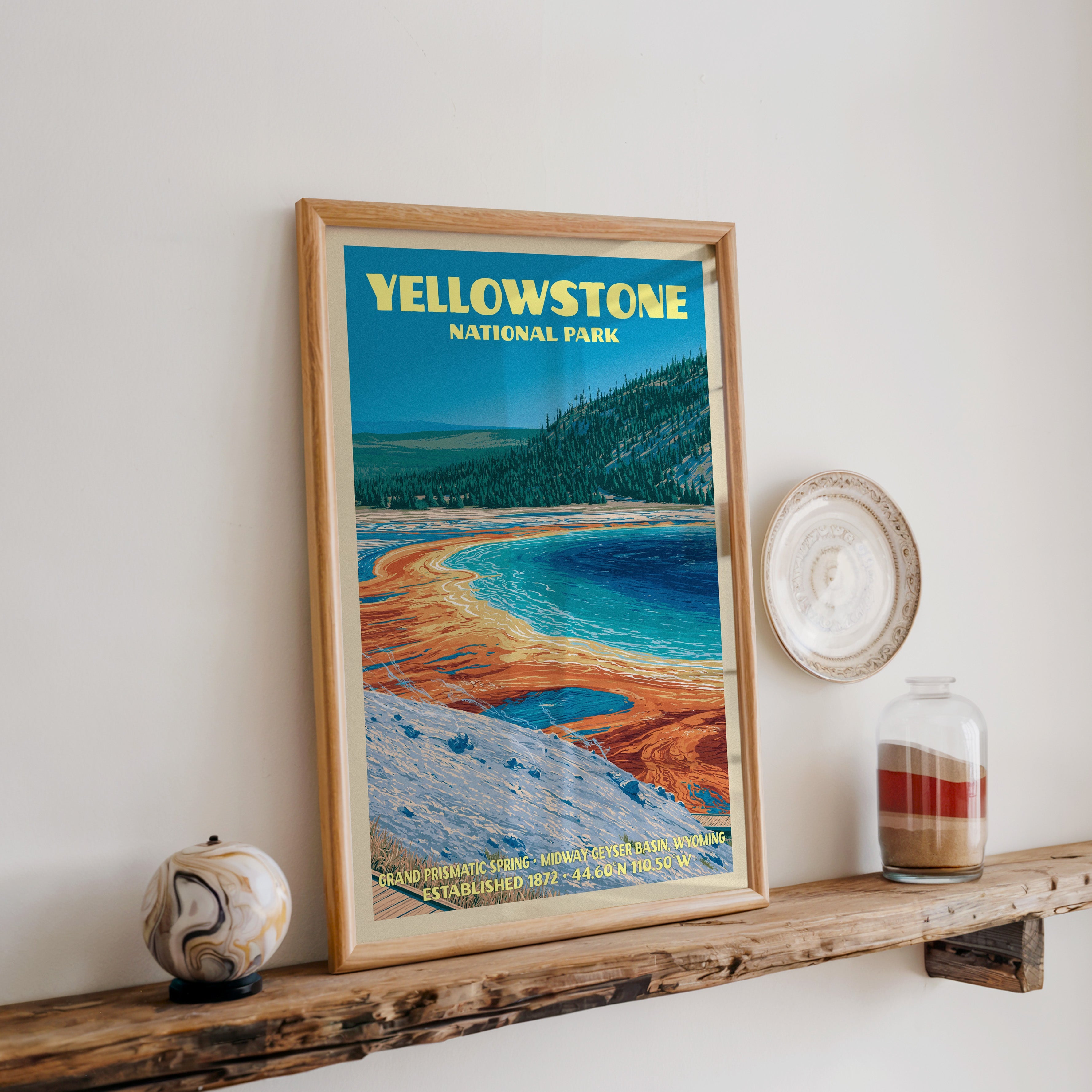 Yellowstone hot spring print in oak, leaning on a reclaimed wood ledge with a marbled sphere and sand jar