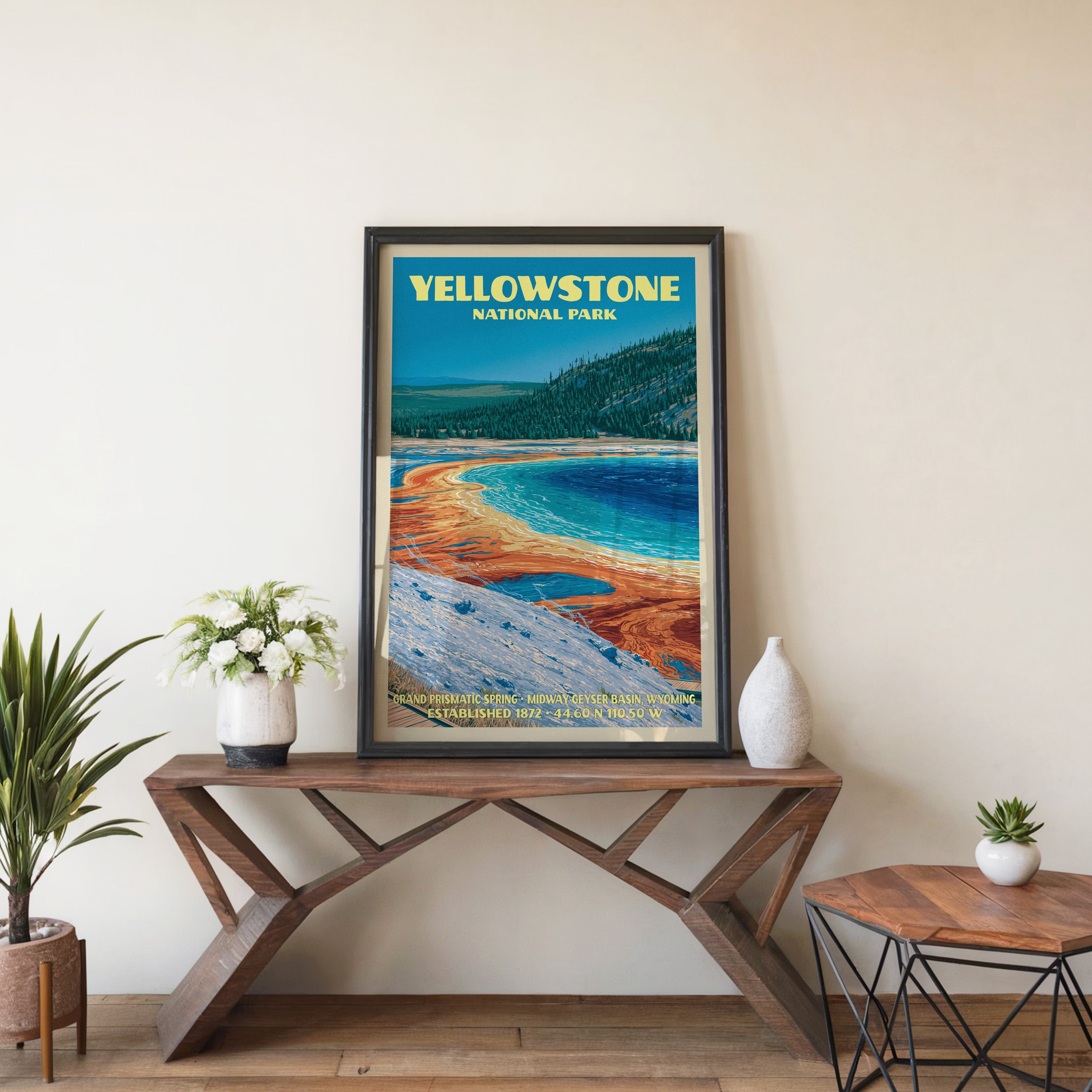 Grand Prismatic Spring wall art in black, leaning on a walnut console with white anemones and a vase
