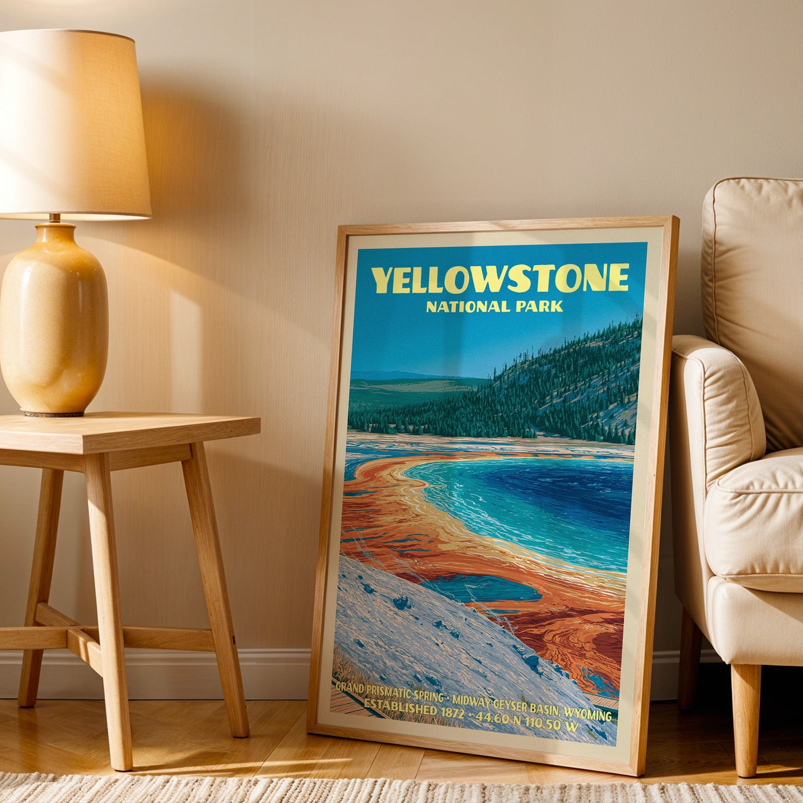 Grand Prismatic Spring wall art in oak, leaning by a cream armchair and a side table with an ochre lamp