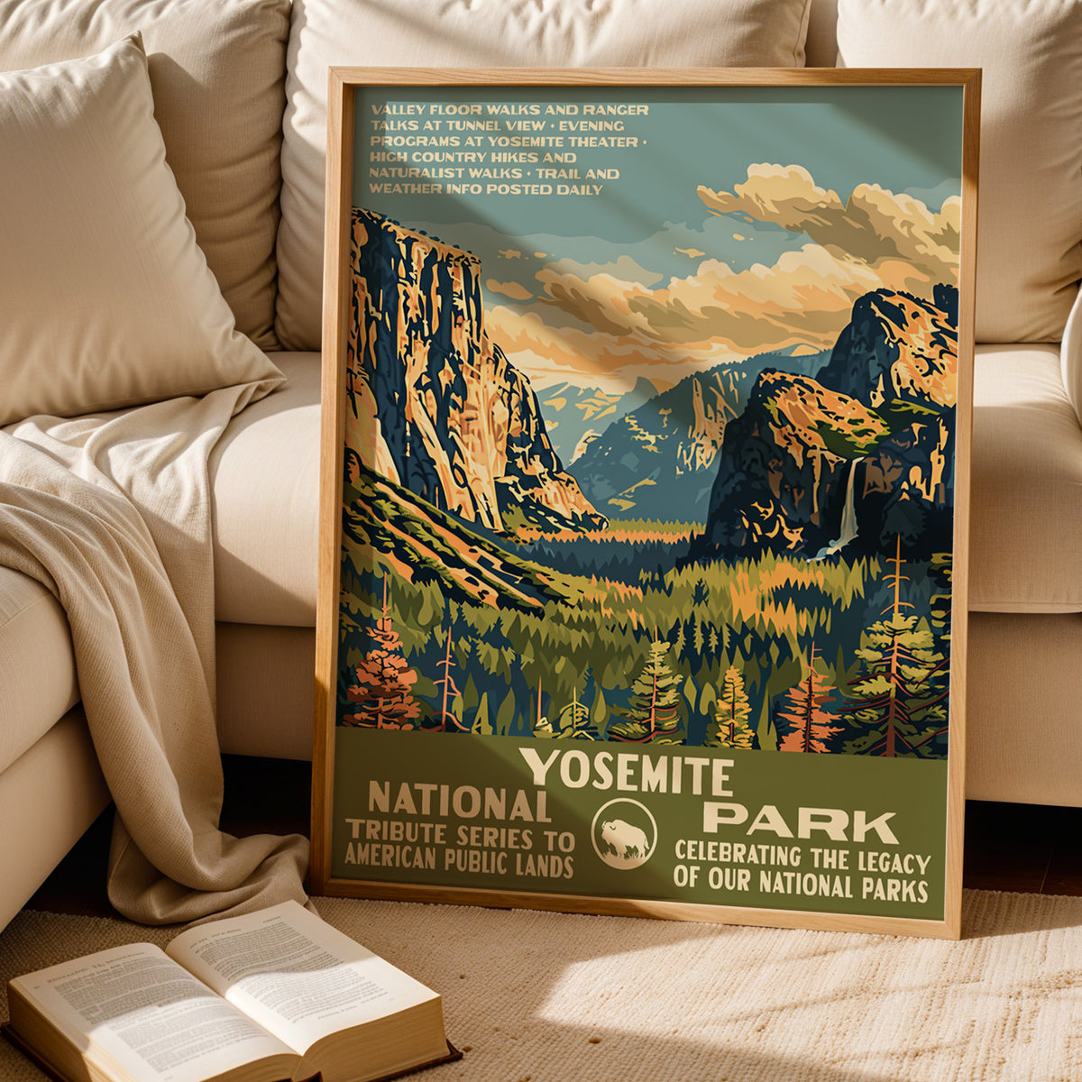 Yosemite National Park WPA print leaning behind a cream sofa above an open book