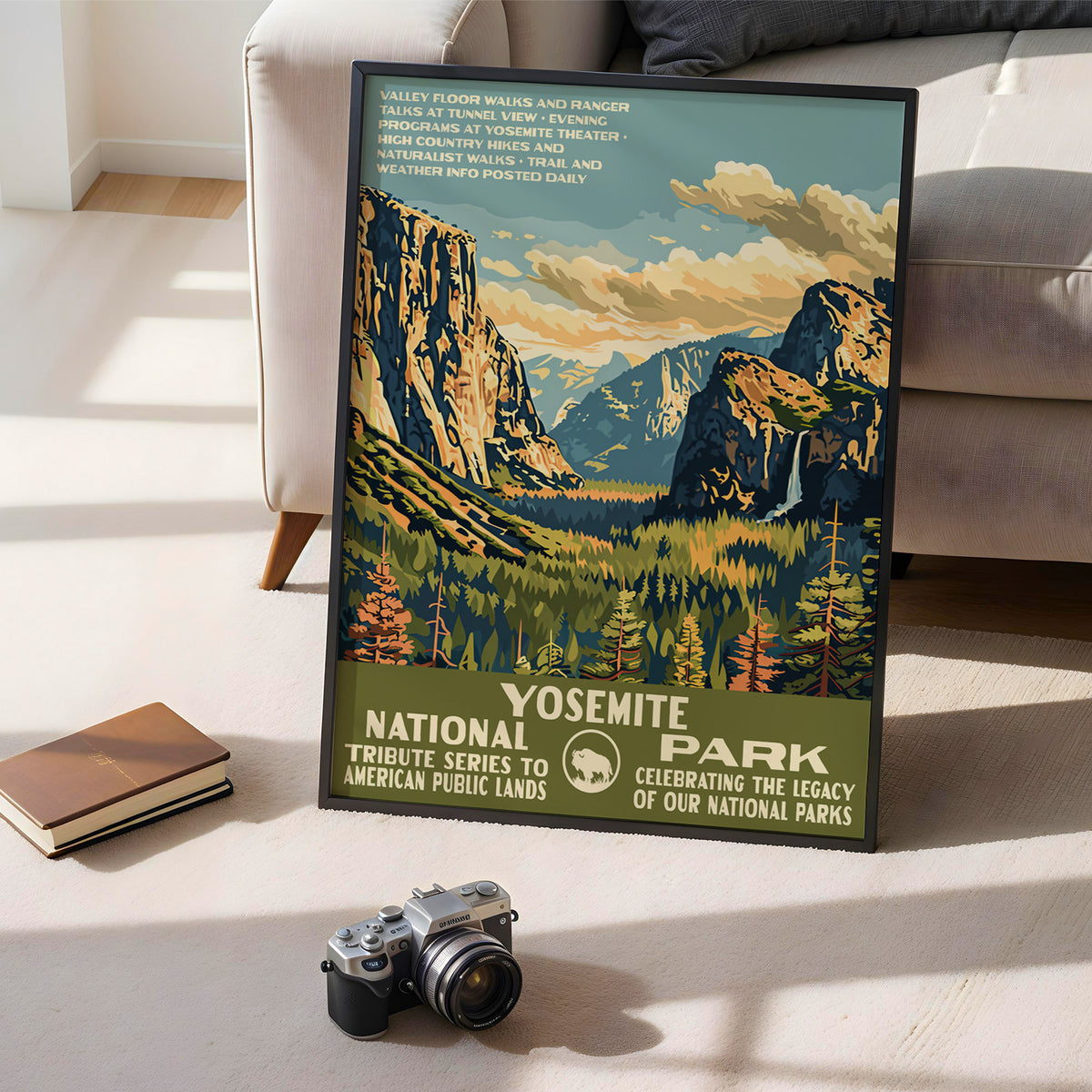 Yosemite National Park poster leaning on the floor beside books and a vintage camera