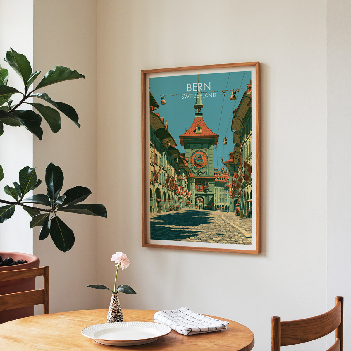 Bern old town poster, walnut frame in a dining corner above a round table and a fiddle-leaf fig