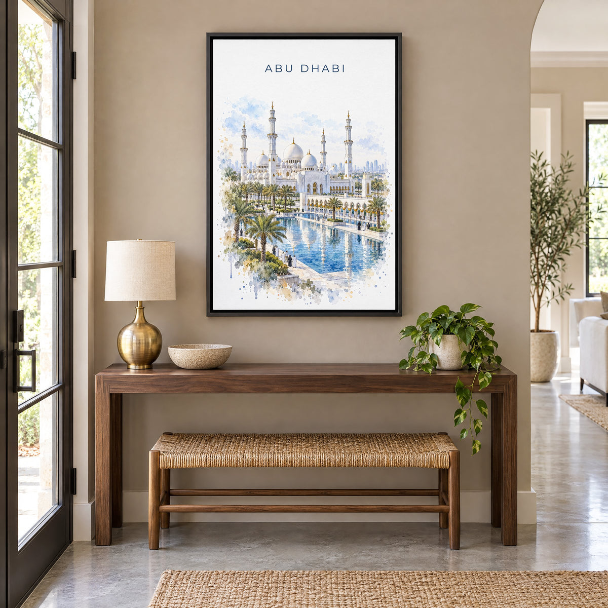 Abu Dhabi watercolor print as a black floater canvas above a walnut console and woven bench in an entryway