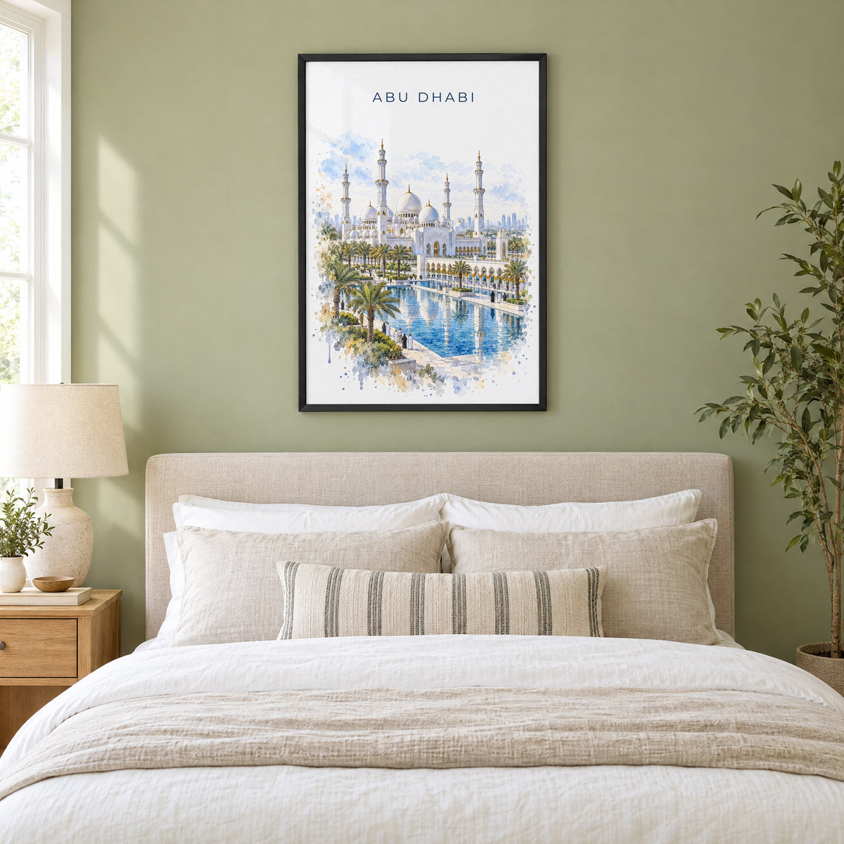 Abu Dhabi watercolor print in a black frame above an upholstered headboard in a sage green bedroom