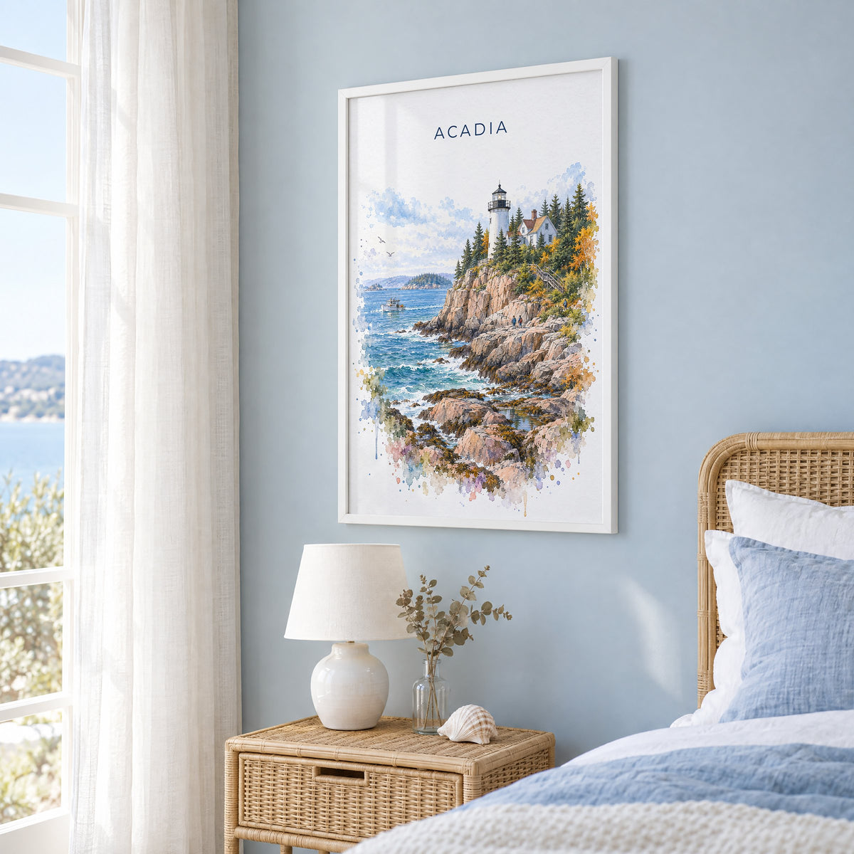 Acadia National Park watercolor print in a white frame on a pale blue wall beside a rattan bed in a coastal bedroom