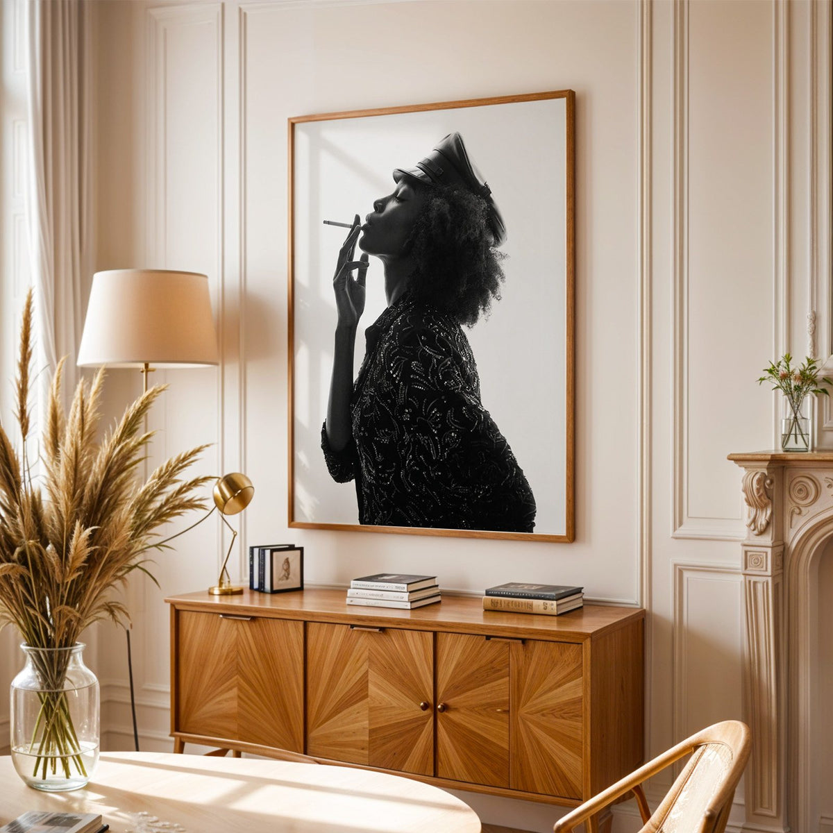 Backlit profile in leather cap with curly hair print in an oak frame above a sunburst wood sideboard with pampas grass