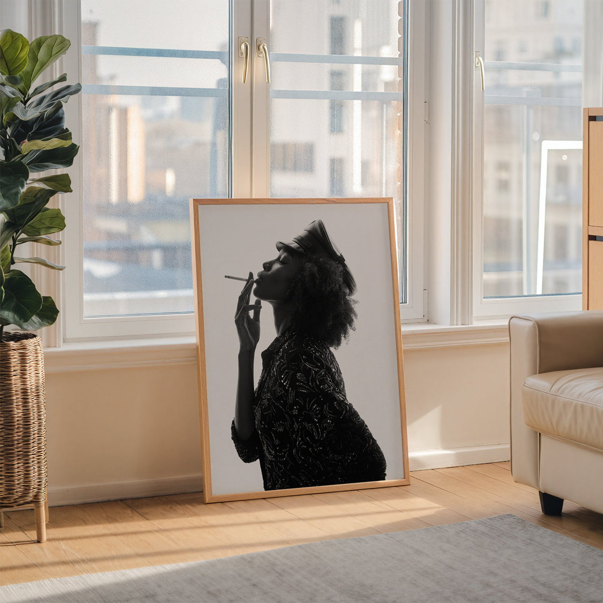 Backlit profile in leather cap with curly hair print in an oak frame leaning on the floor beside a fiddle leaf fig