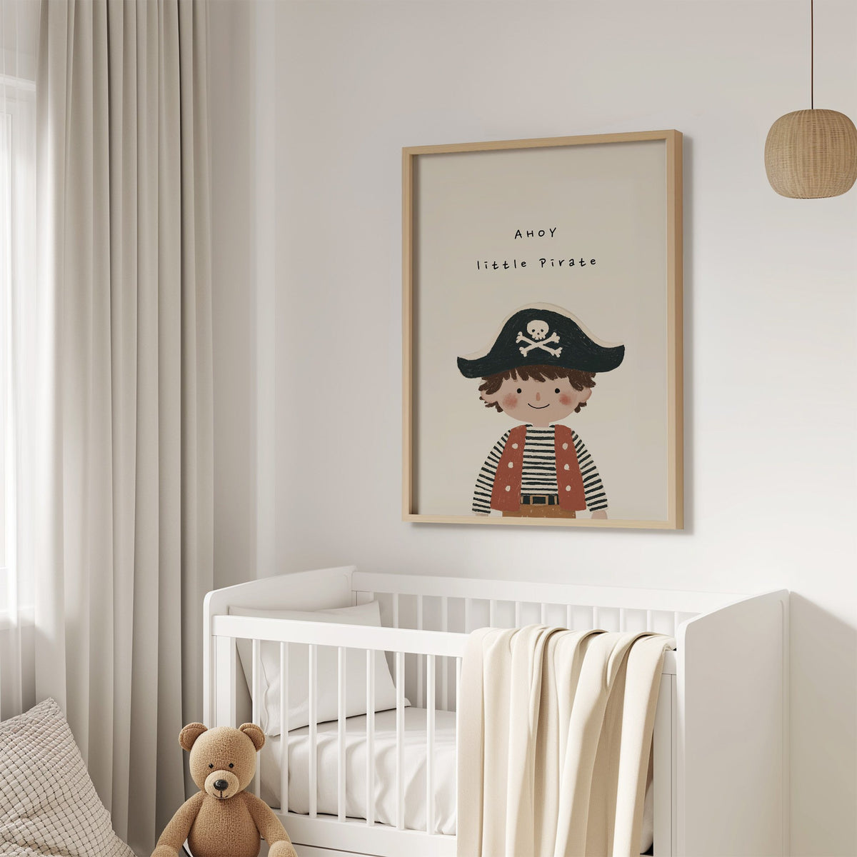 Ahoy little pirate boy nursery print in an oak frame above a white crib with a teddy bear