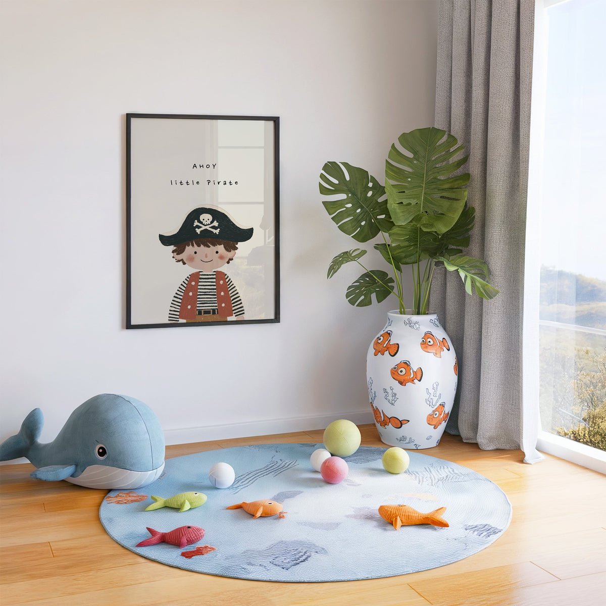 Ahoy little pirate boy nursery print in a black frame in a playroom with an ocean rug and whale plush