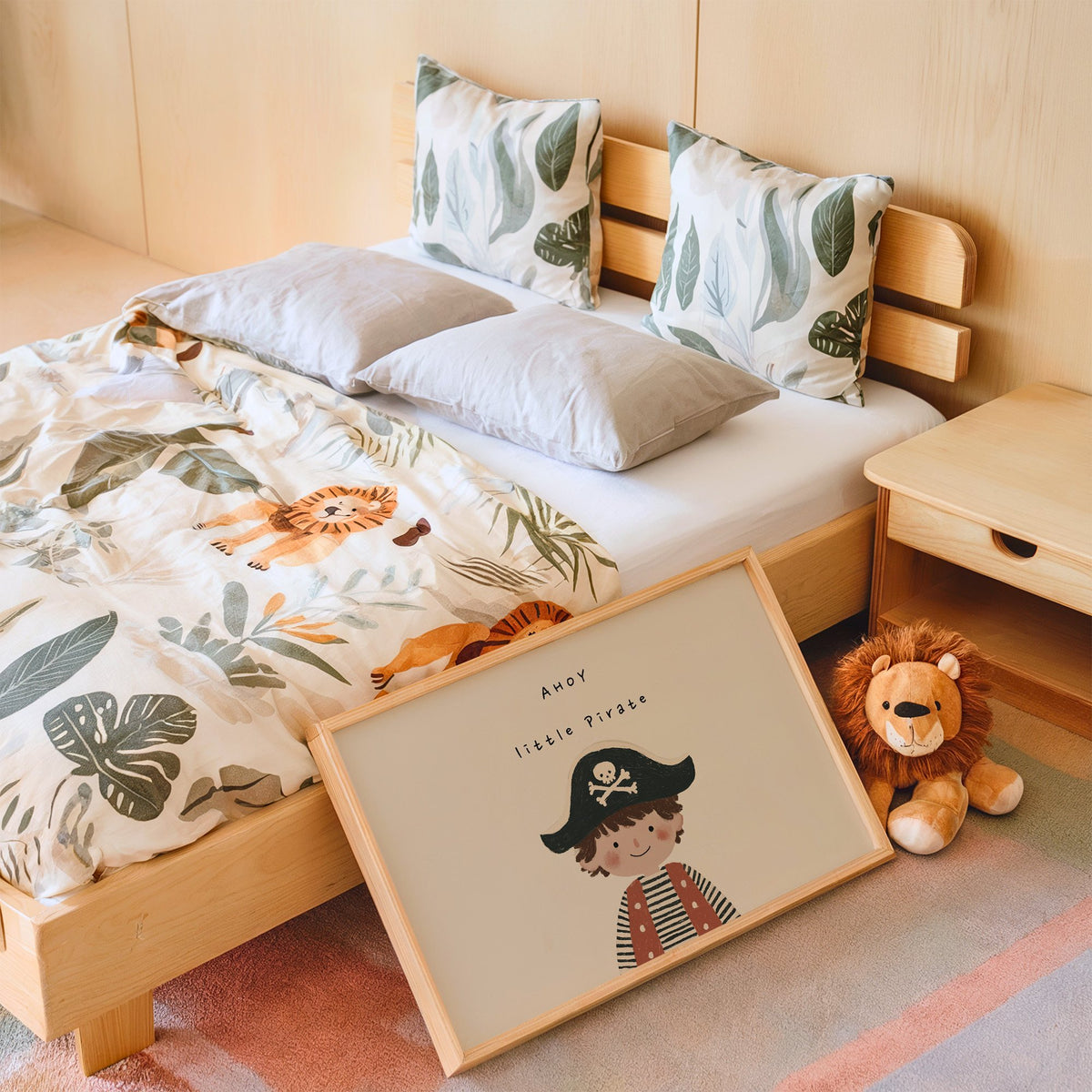 Landscape ahoy little pirate boy nursery print in an oak frame leaning on a kids bed by a lion plush