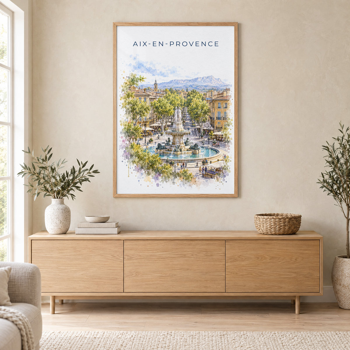 Aix-en-Provence watercolor print in an oak frame above a light wood sideboard in a Scandinavian living room