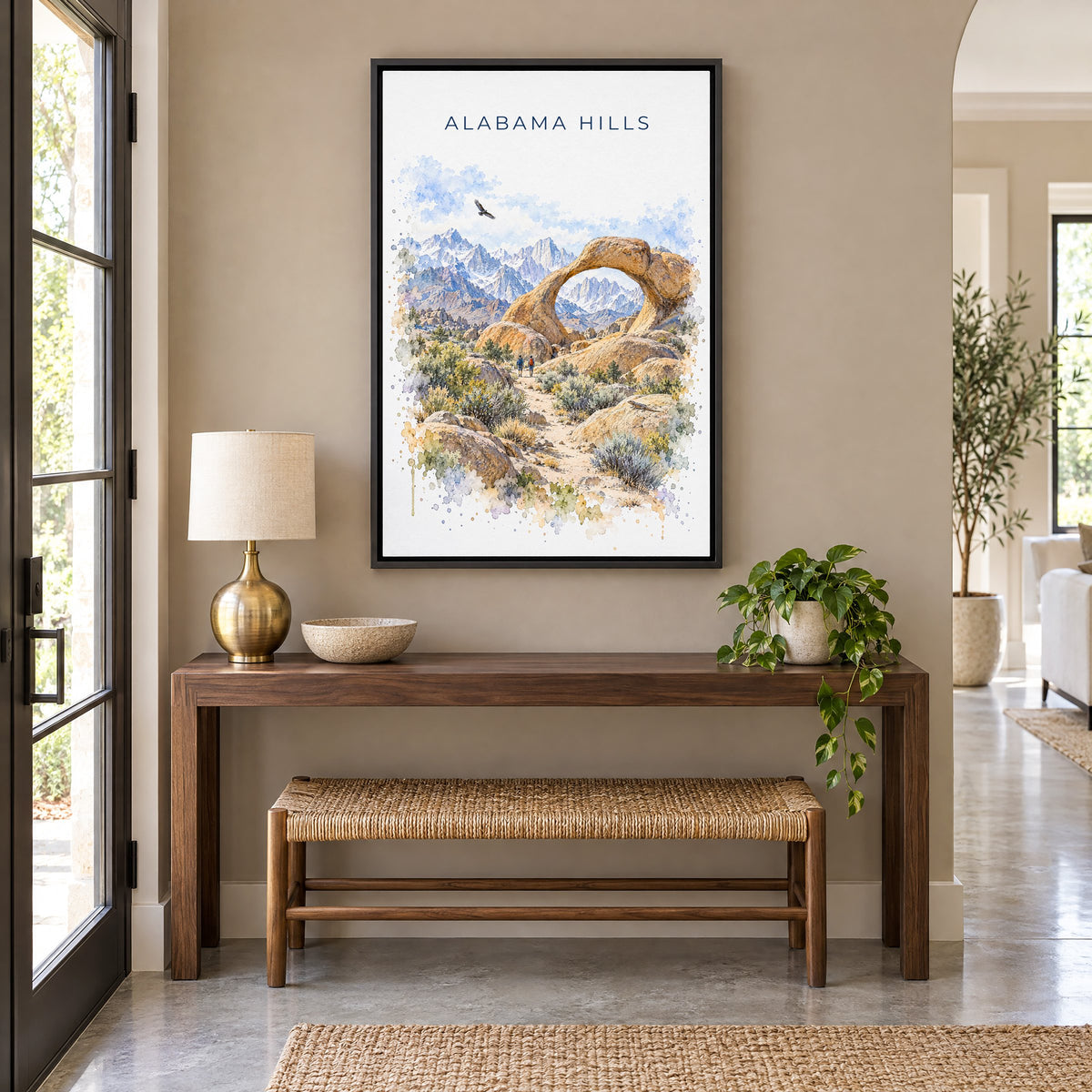 Alabama Hills watercolor print as a black floater canvas above a walnut console and woven bench in an entryway