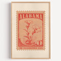 Alabama state flower stamp print in brick red on peach, light oak frame on a plain white wall