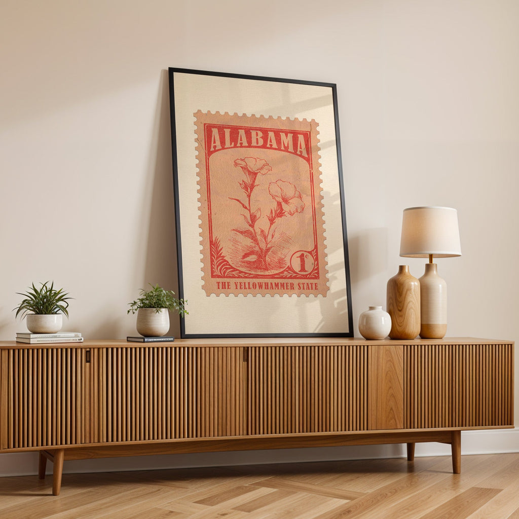 Alabama state flower print in a black frame leaning on a fluted wood credenza with vases and a table lamp