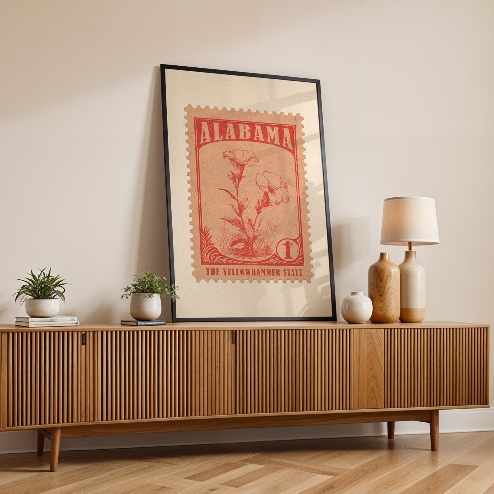 Alabama state flower print in a black frame leaning on a fluted wood credenza with vases and a table lamp