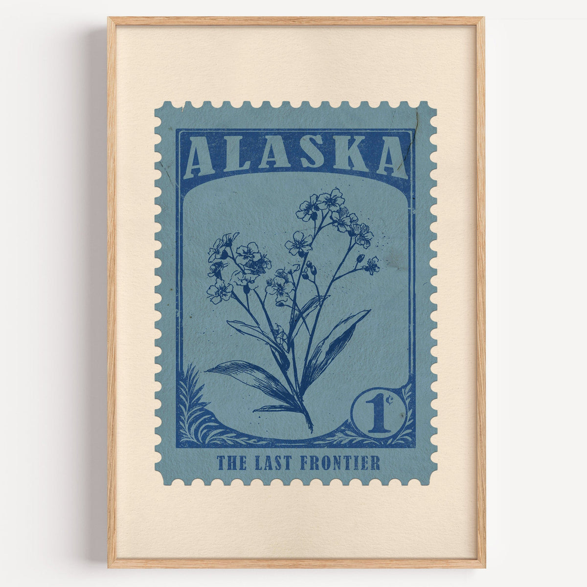 Alaska state flower stamp print in ink blue on dusty sky, light oak frame on a plain white wall