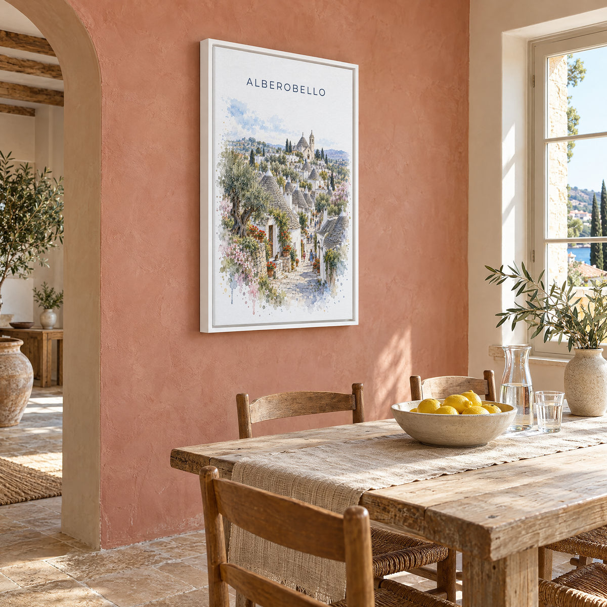 Alberobello watercolor print as a white floater canvas on a terracotta wall above a rustic dining table