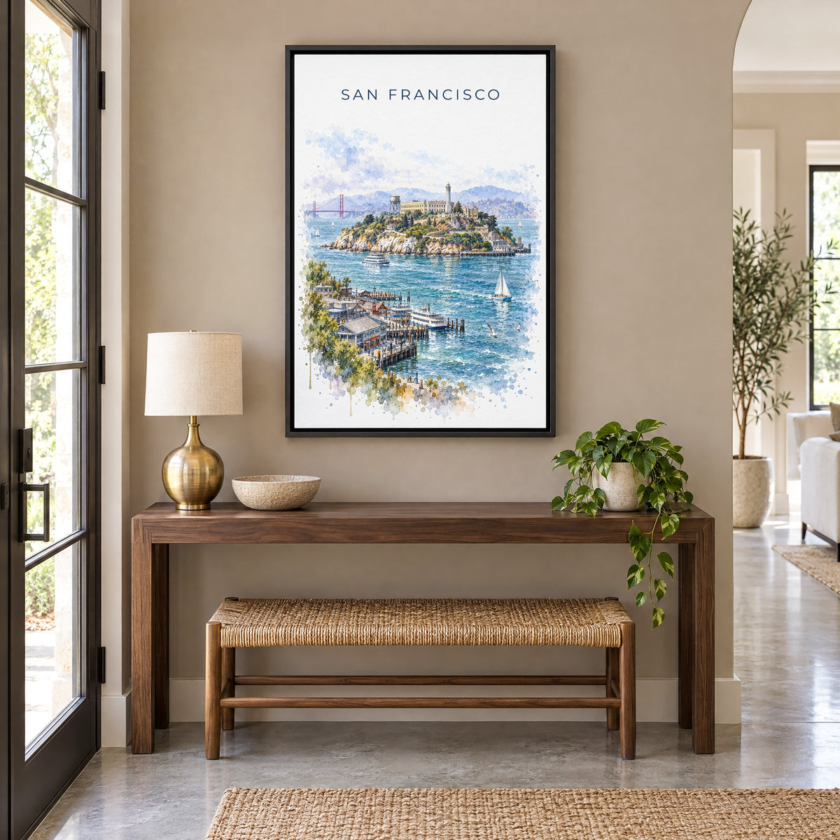 Alcatraz Island watercolor print as a black floater canvas above a walnut console and woven bench in an entryway