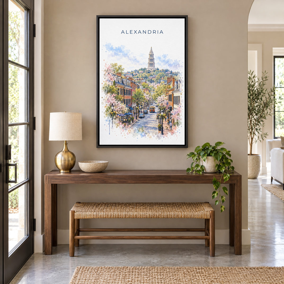 Alexandria watercolor print as a black floater canvas above a walnut console and woven bench in an entryway
