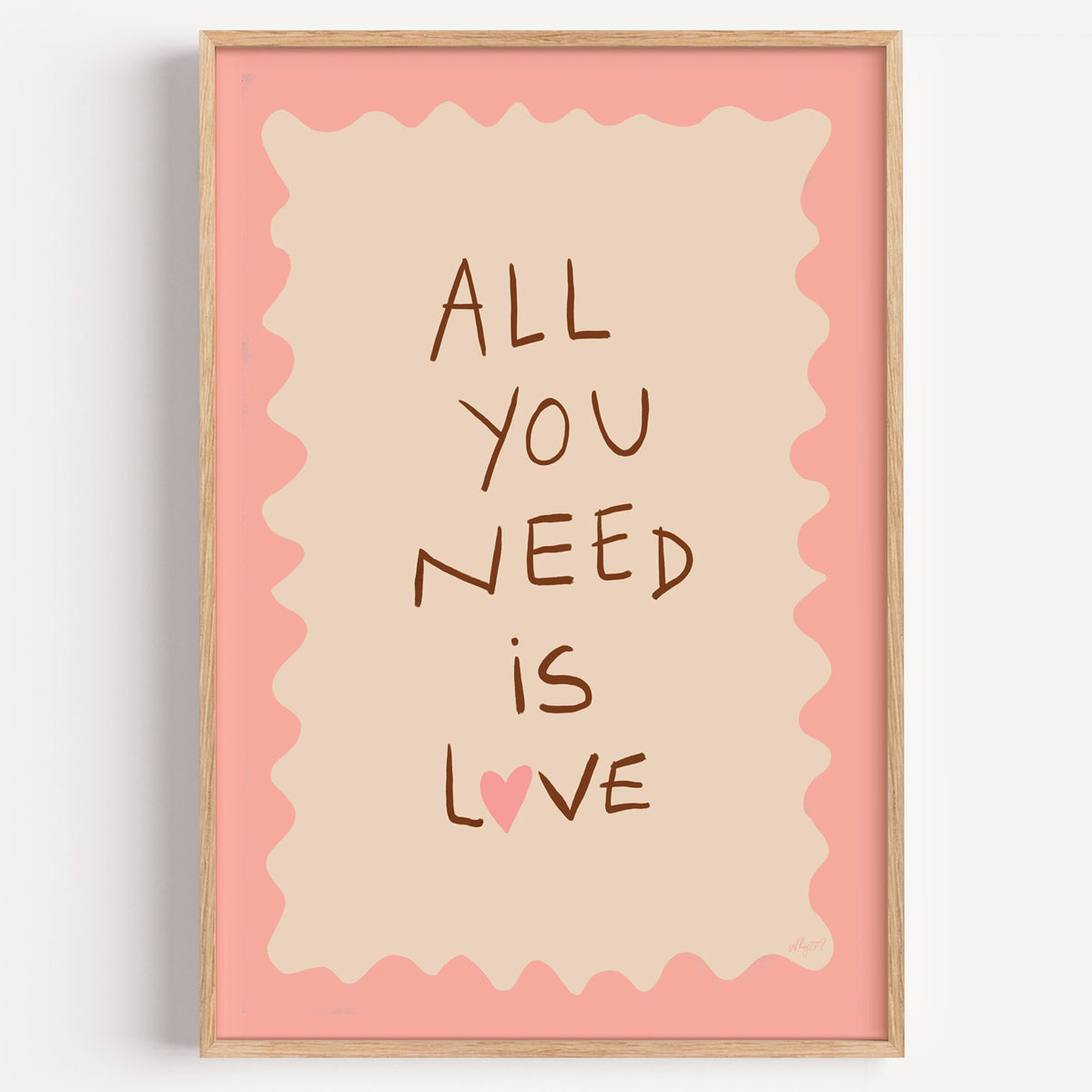 All you need is love lettering nursery print in a light oak frame on a plain white wall