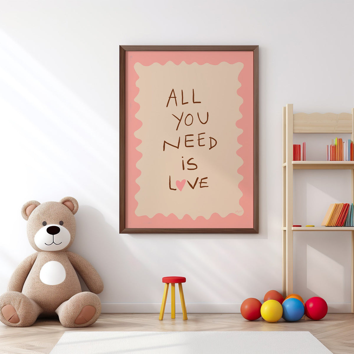 All you need is love lettering nursery print in a walnut frame above a big teddy bear by a bookshelf
