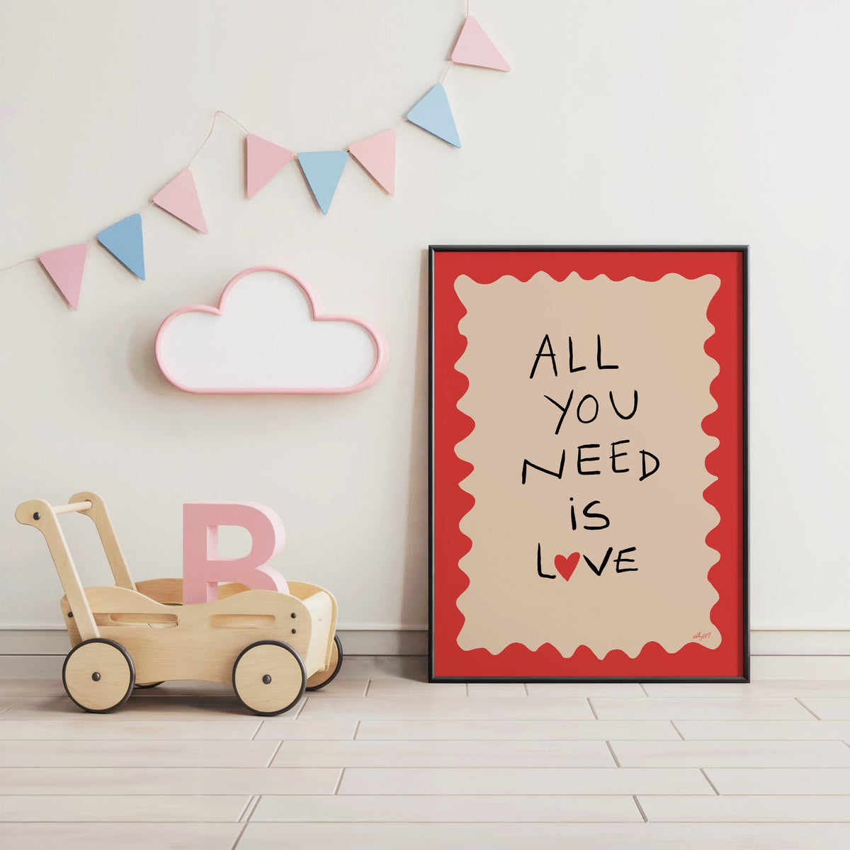 All you need is love heart nursery print in a black frame under pastel bunting by a wooden baby walker