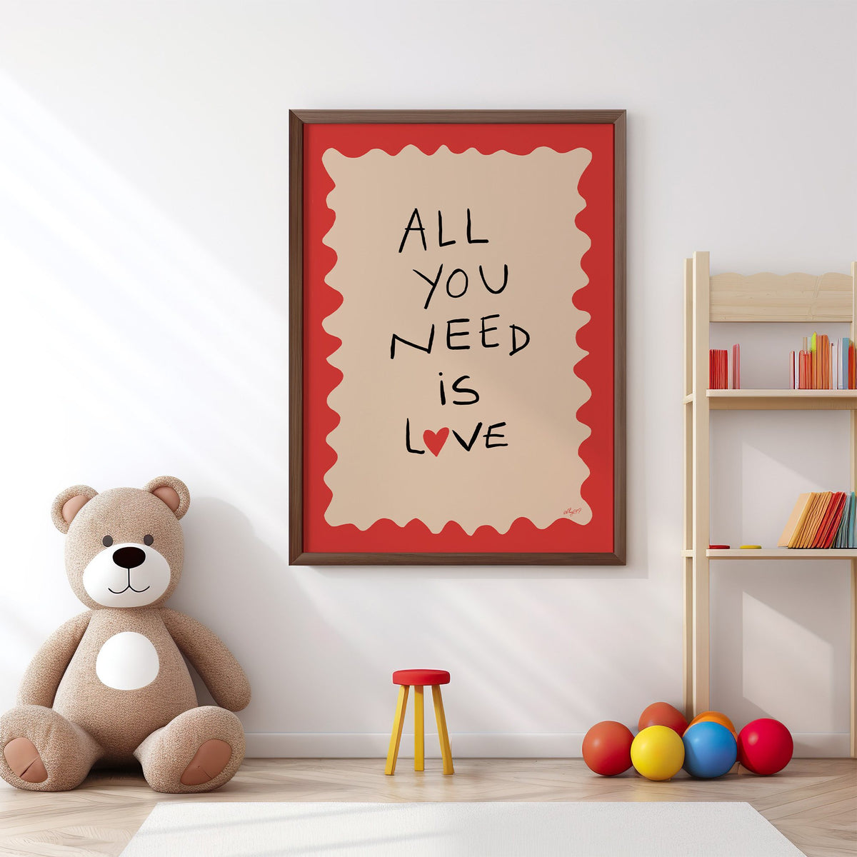 All you need is love heart nursery print in a walnut frame above a big teddy bear by a bookshelf