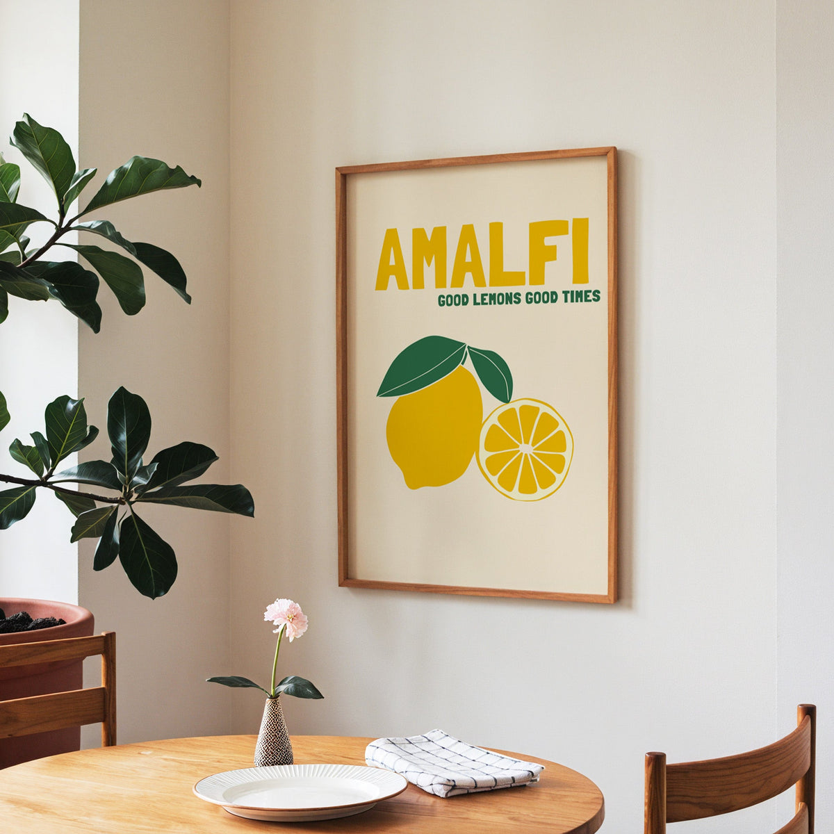 Amalfi lemon print in a walnut frame above a round table beside a fiddle-leaf fig