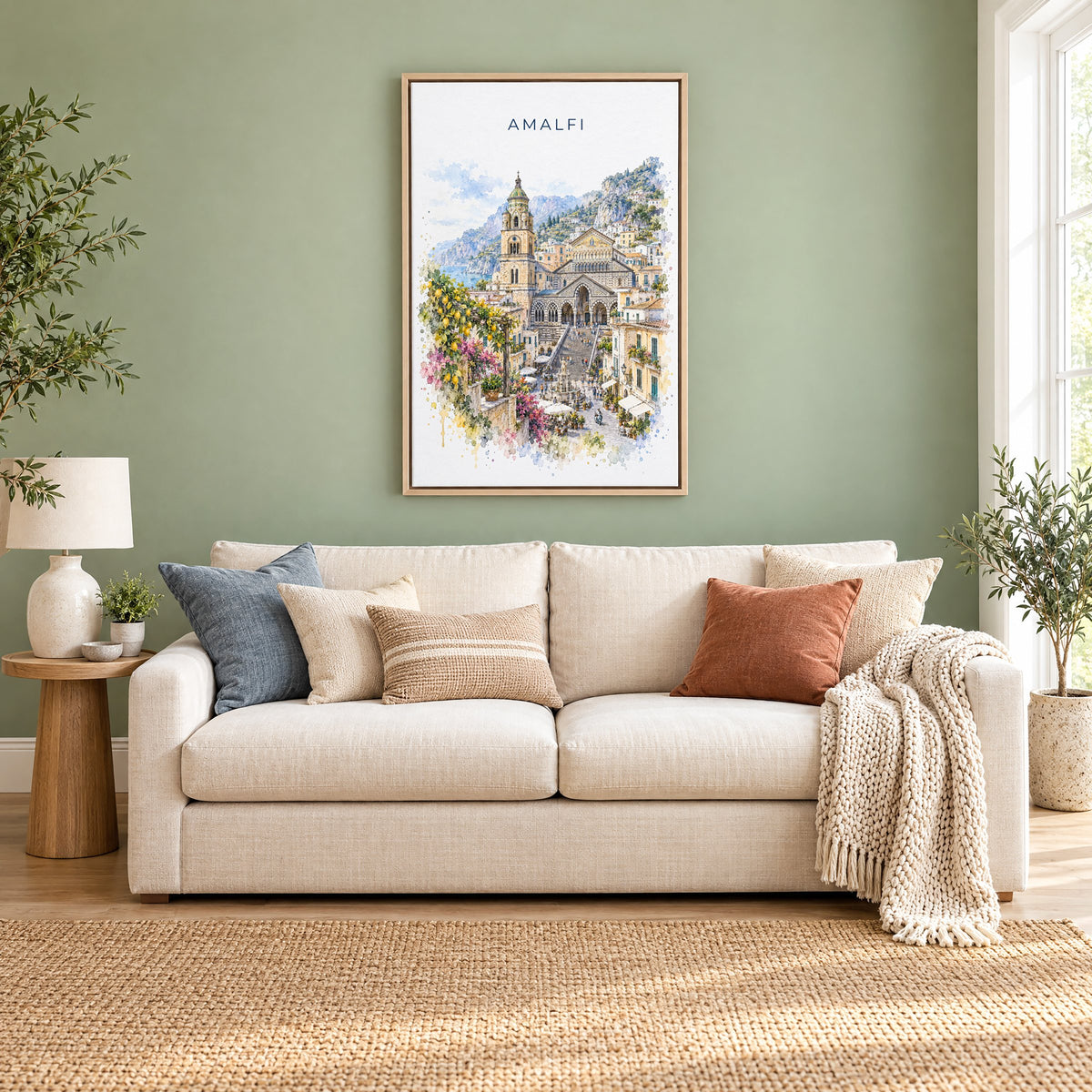 Amalfi watercolor print as a natural floater canvas above a cream linen sofa on a sage green wall