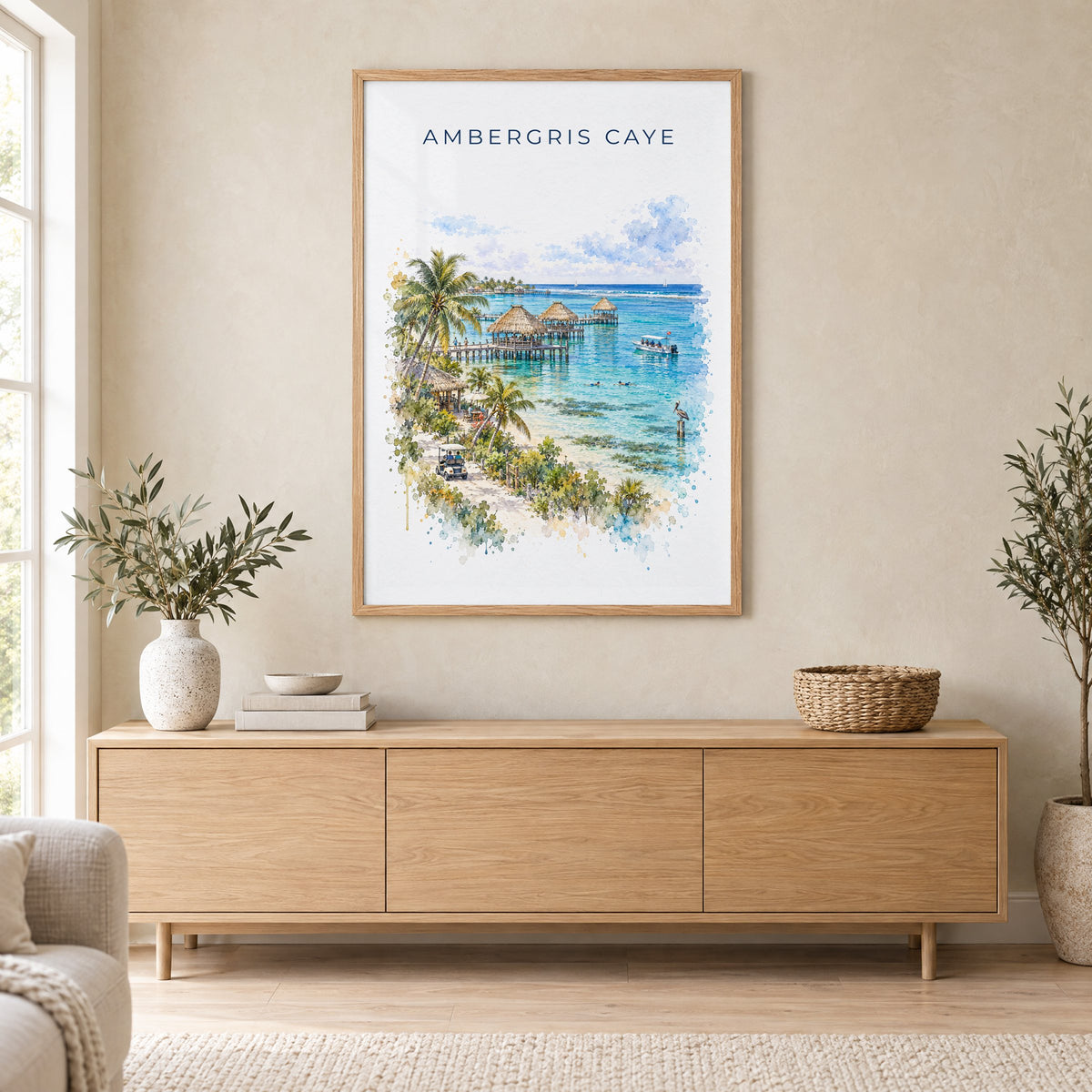 Ambergris Caye watercolor print in an oak frame above a light wood sideboard in a Scandinavian living room