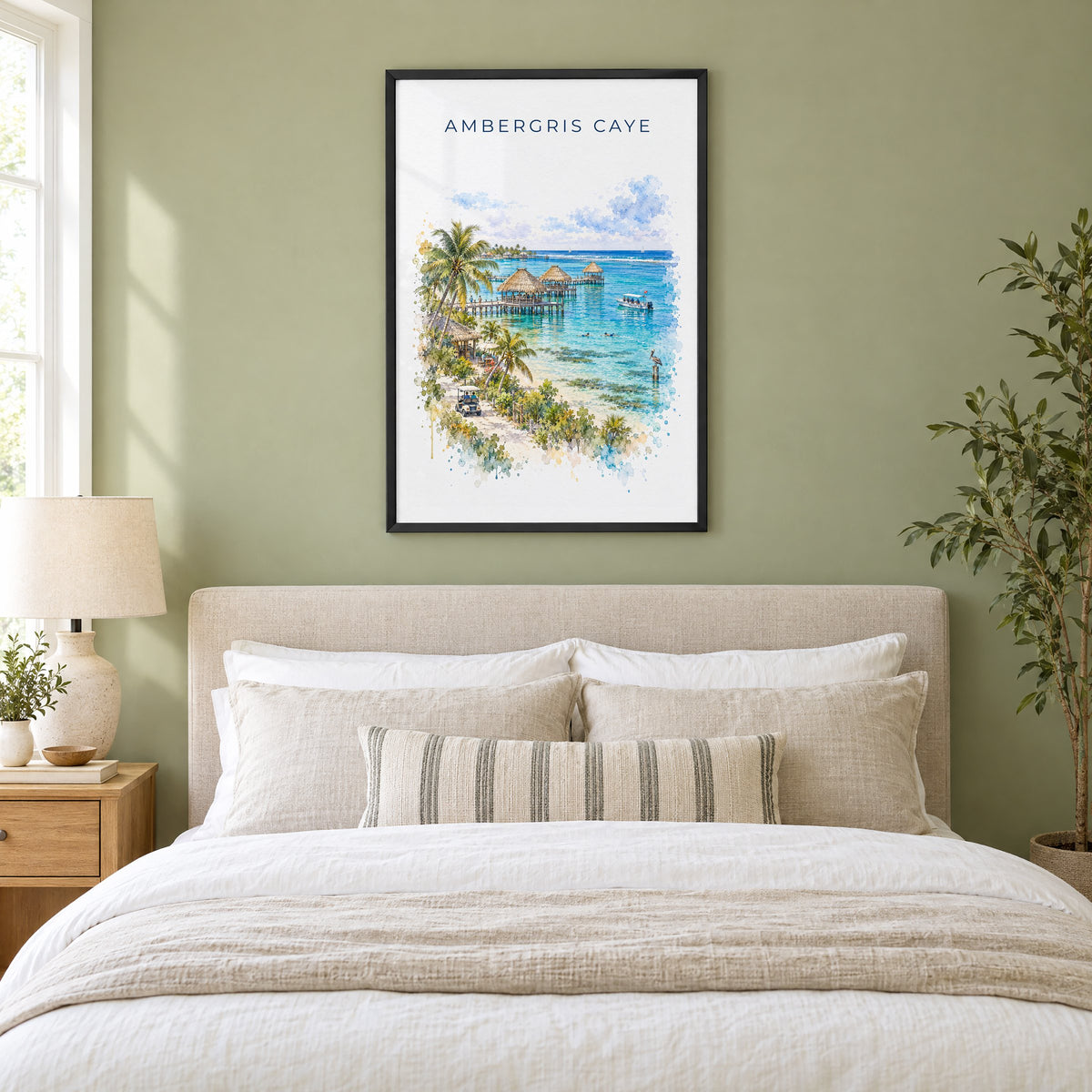 Ambergris Caye watercolor print in a black frame above an upholstered headboard in a sage green bedroom