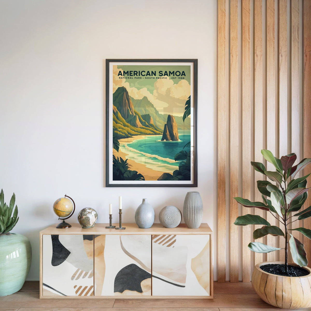 American Samoa National Park print in a black frame above a light wood sideboard with a globe