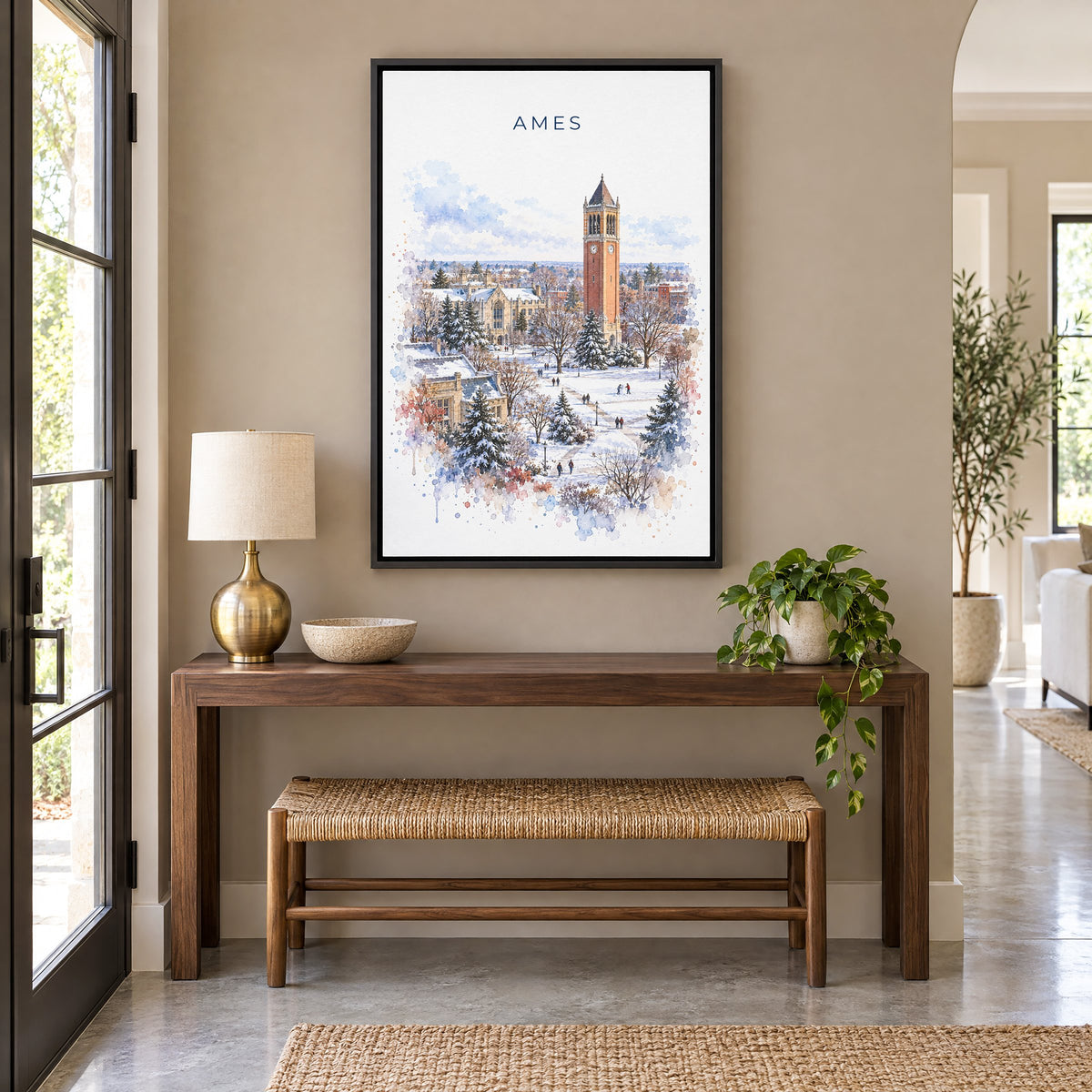 Ames, Iowa watercolor print as a black floater canvas above a walnut console and woven bench in an entryway