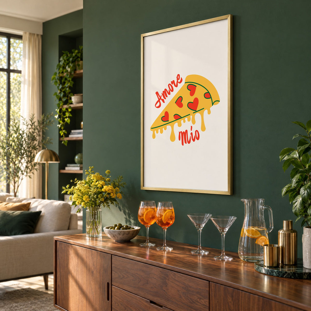 Amore Mio heart pizza slice print in a brass frame on a bottle green wall above a sideboard with spritz and martini glasses, seen at an angle