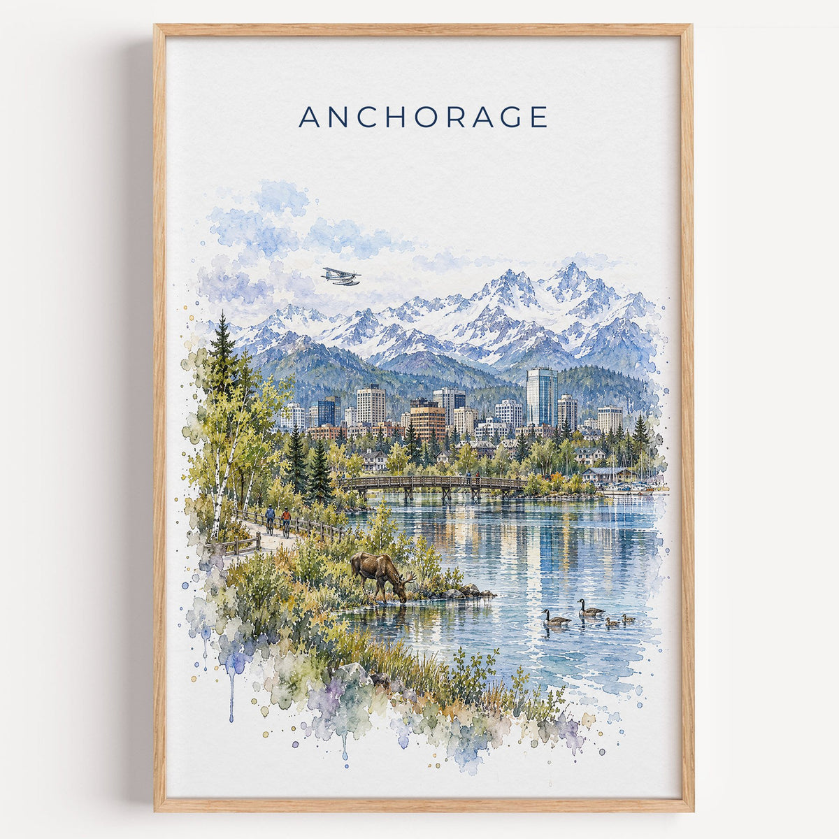 Anchorage watercolor print in a light oak frame on a plain white wall