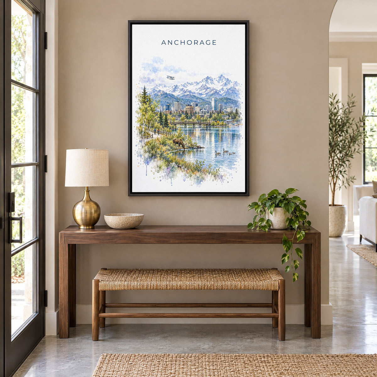 Anchorage watercolor print as a black floater canvas above a walnut console and woven bench in an entryway