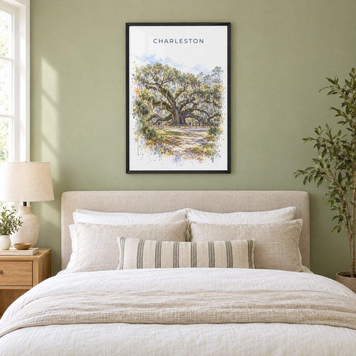 Angel Oak Charleston watercolor print in a black frame above an upholstered headboard in a sage green bedroom