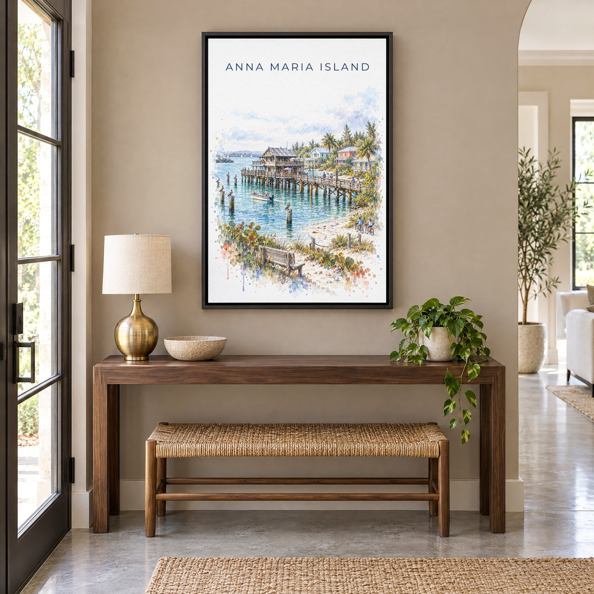 Anna Maria Island watercolor print as a black floater canvas above a walnut console and woven bench in an entryway