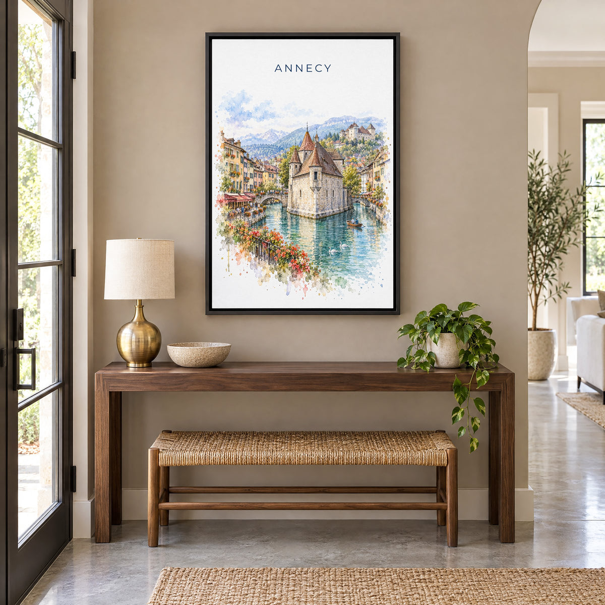 Annecy watercolor print as a black floater canvas above a walnut console and woven bench in an entryway