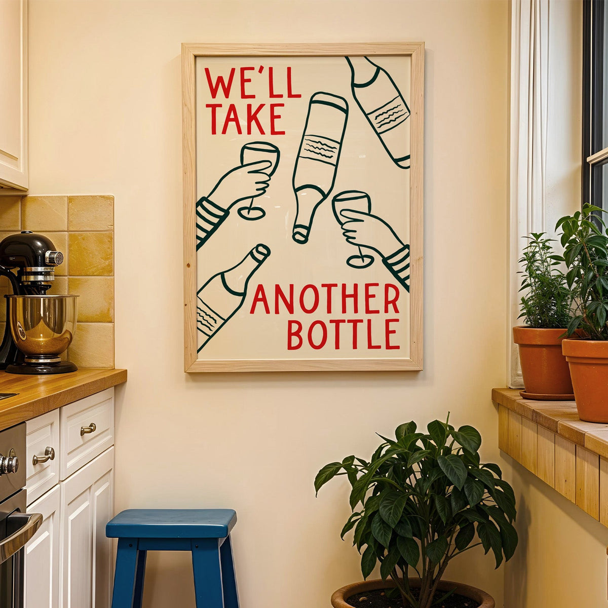 We'll Take Another Bottle wine print in a wood frame on a yellow tiled kitchen wall