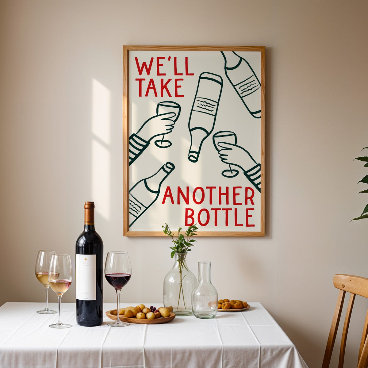 We'll Take Another Bottle wine print in an oak frame above a table laid with red wine and glasses