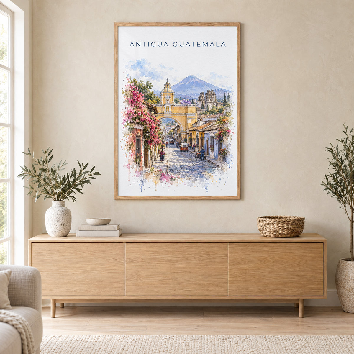 Antigua Guatemala watercolor print in an oak frame above a light wood sideboard in a Scandinavian living room