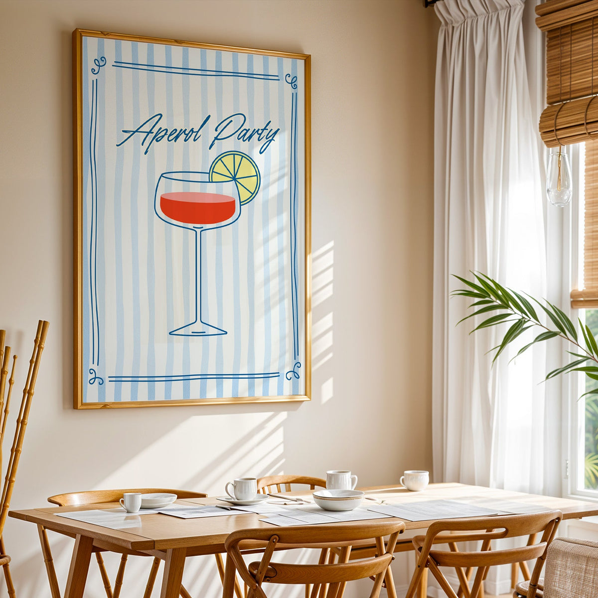Aperol Party print shown in a gold frame above a breakfast table by a curtained window