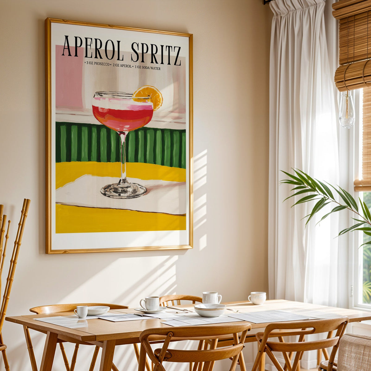Aperol Spritz recipe print shown in a gold frame above a breakfast table by a curtained window