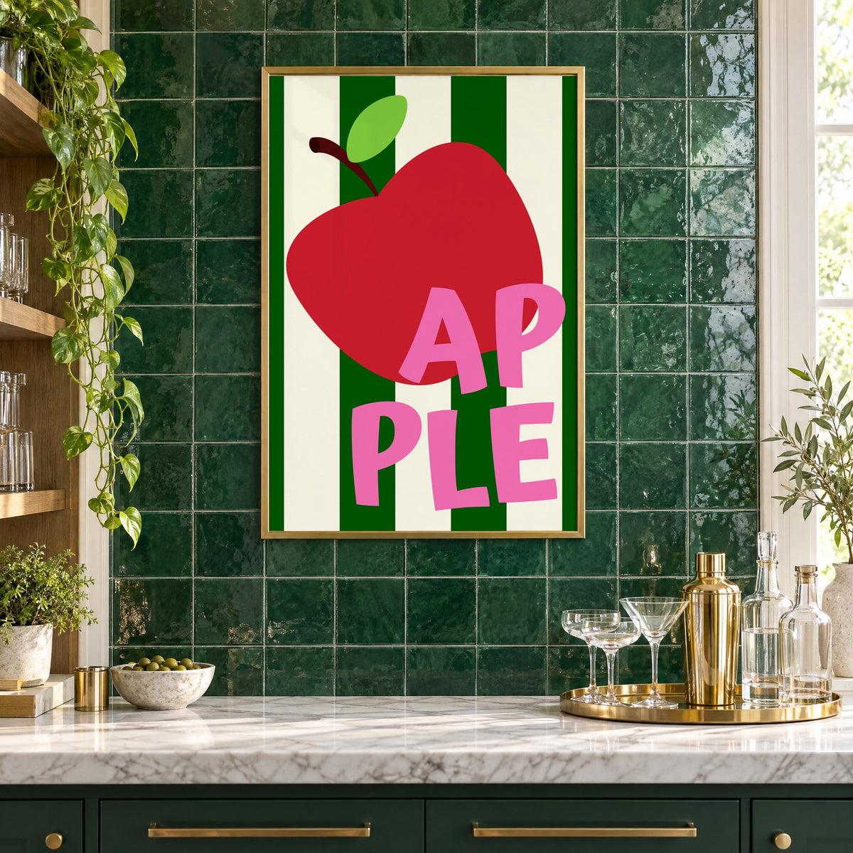 AP PLE red apple stripes print in a brass frame on emerald green tiles above a home bar with coupe glasses