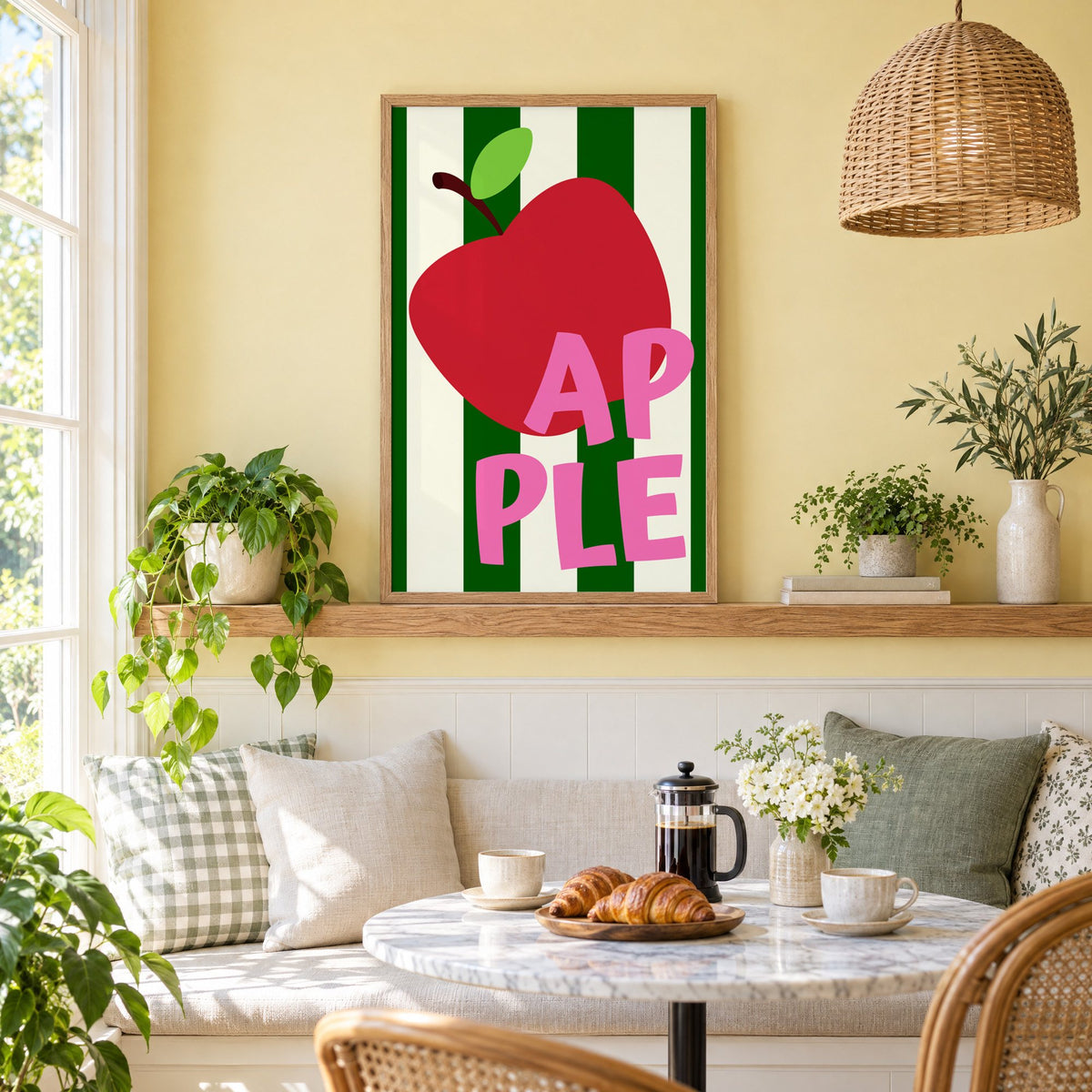 AP PLE red apple stripes print in an oak frame on a picture ledge above a sunny breakfast nook