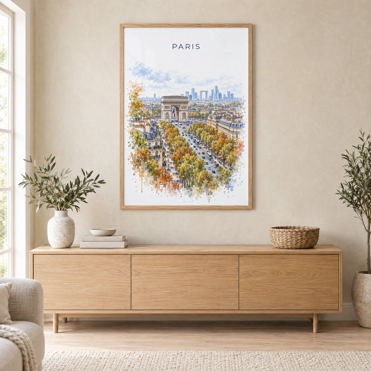 Arc de Triomphe watercolor print in an oak frame above a light wood sideboard in a Scandinavian living room