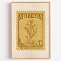 Arizona state flower stamp print in bronze gold on wheat, light oak frame on a plain white wall